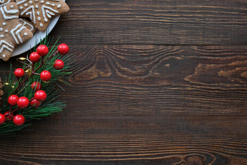 Christmas background with gingerbread cookies on a plate and wooden brown texture