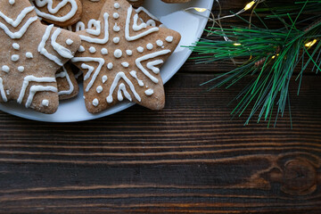 Christmas background with gingerbread cookies on a plate and wooden brown texture