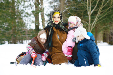 Traditional Russian holiday in early spring. Seeing off winter. Mardi gras. Family with children in the winter in the park.