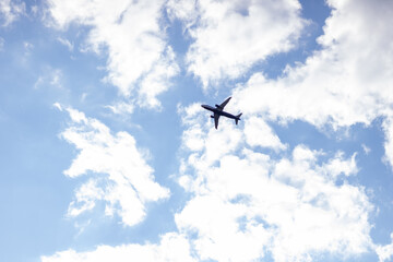 Airplane in the sky among the clouds. Blue sky. sunny day