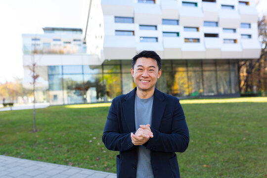 Portrait Handsome Asian Man A University College Teacher, Businessman, Scientist Cheerful Happy Educator. Standing Background Modern Office Center Or Campus. Outside, Outdoors Looking At Camera. Smile