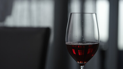 red wine in wineglass indoor with window on background