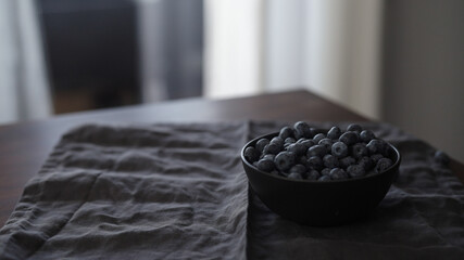 Fototapeta na wymiar fresh blueberries in black bowl on table