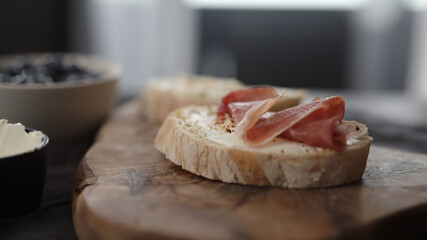 prosciutto over cream cheese on slice of ciabatta