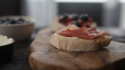 prosciutto over cream cheese on slice of ciabatta
