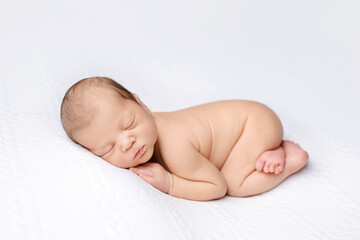 Newborn baby sleeps on white background. Cute sleeping newborn. Child's portrait.