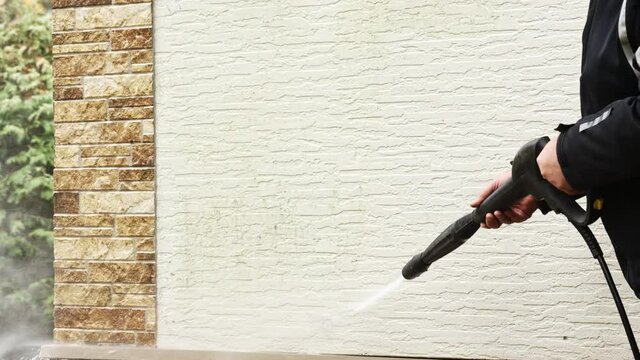 Man cleaning walls with high pressure power washer. Washing cladding walls house. High quality 4k footage
