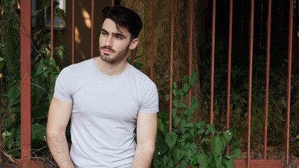 Handsome young man outdoor, standing and looking away