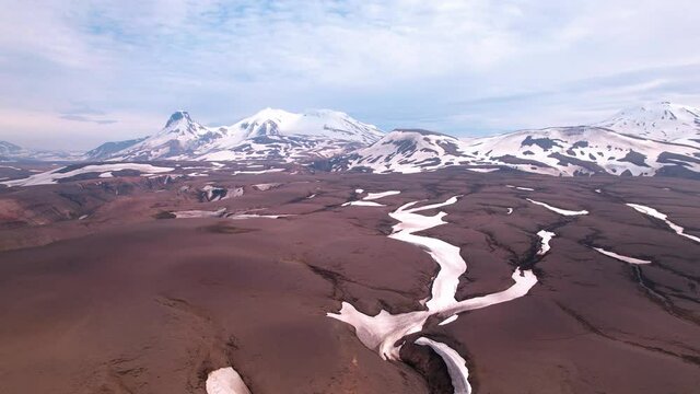 Sideways moving aerial shot view of snow covered mountains in Iceland. Highlands of the country, dramatic epic landscape.