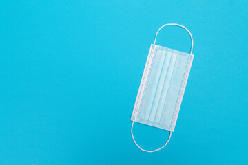 Blue Medical Mask on Blue Background - Top View, Flat Lay