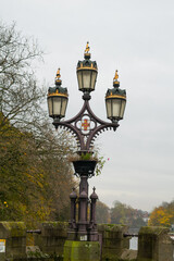 Fototapeta na wymiar Close view of old black lamp post with royal decorations at the Skeldergate Bridge in York England