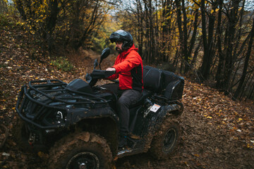 Quad bike rider in the autumn forest