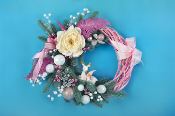 Beautiful handmade Christmas wreath with festive decor on blue background. Christmas composition.