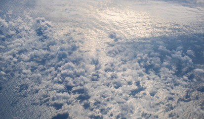 Aerial evening sky and clouds view above ocean from airplane porthole. Sky cloudscape background. Flight to Iceland over the North Atlantic.