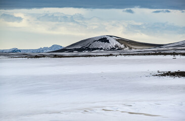 Colorful Landmannalaugar mountains under snow cover in autumn, Iceland. Lava fields of volcanic sand in the foreground.