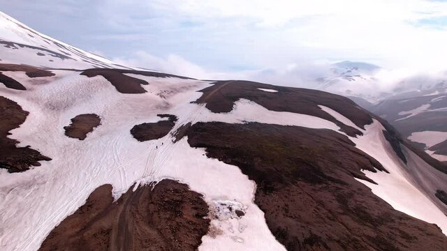 Turning aerial shot of hikers in snowy mountains, shot in Iceland. Grand, epic landscape shot in kerlingarfjöll. 