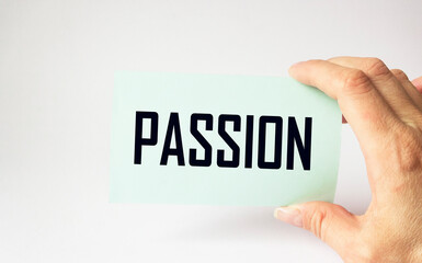 Passion words on a note in a man's hand on a light background