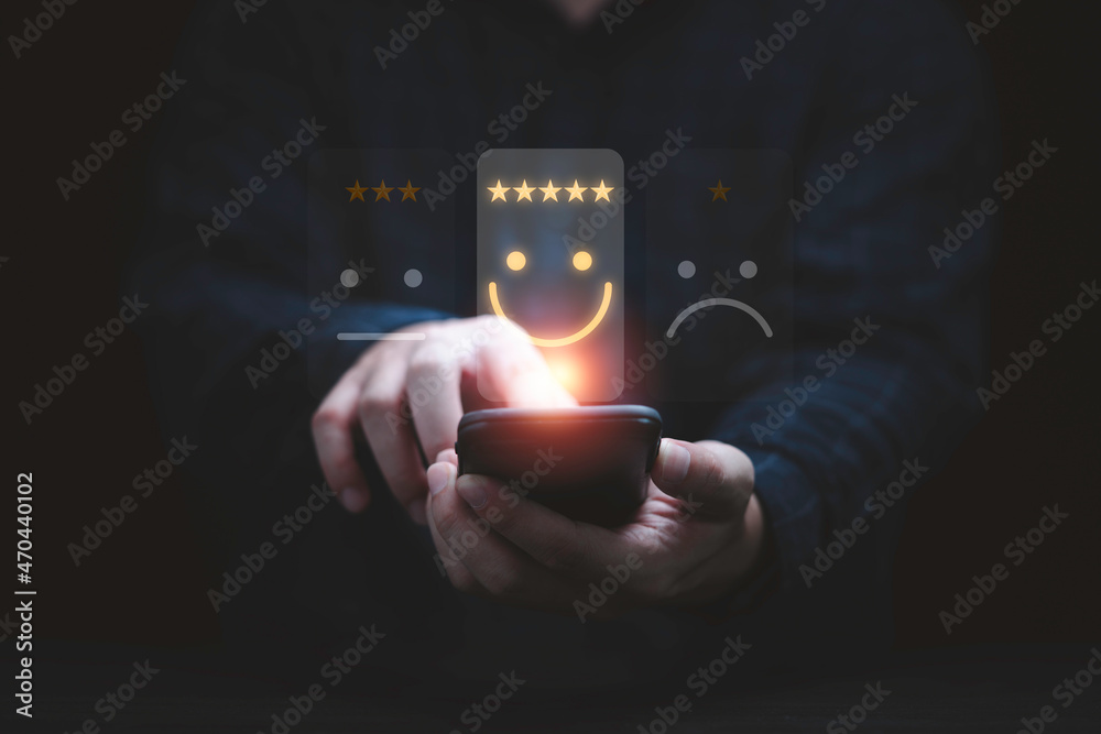 Poster Businessman using smartphone for select smiley face icon for client evaluation and customer satisfaction after use product and service concept.