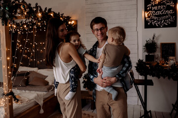Beautiful young family near a Christmas tree on Christmas Eve