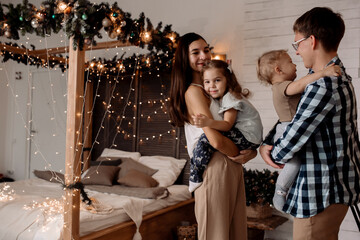 Fototapeta premium Beautiful young family near a Christmas tree on Christmas Eve