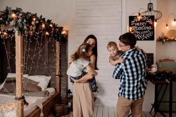 Beautiful young family near a Christmas tree on Christmas Eve