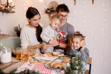 Young parents preparing breakfast with children for christmas