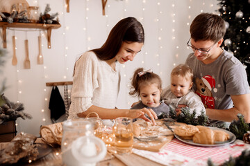 Young parents preparing breakfast with children for christmas