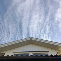  low angle shot of a window and a roof of a house with blue sky in Norway