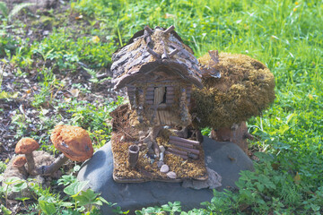 A toy homemade house of a fairy-tale creature made of logs and branches in the park