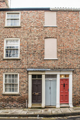 Fototapeta na wymiar Facade of traditional British brick terraced houses with colorful doors in York England