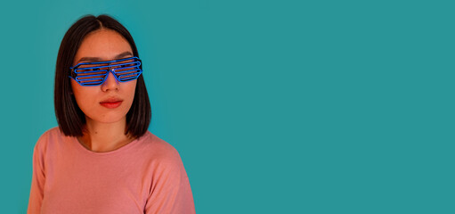 Fototapeta na wymiar Young woman wearing headphones and futuristic led glasses on background isolated on copyspace cropped banner