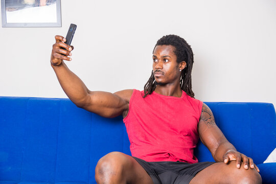 Black young man taking selfie photo on sofa