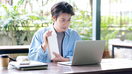 Online education learning, Work from home, Man hand writing on notebook while using laptop...