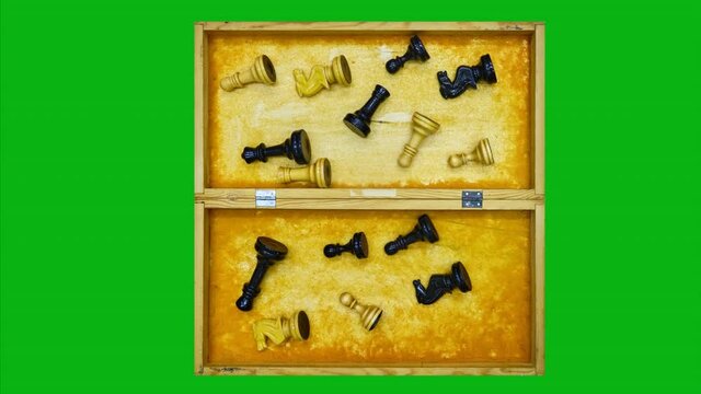 An inverted old chessboard for collecting retro pieces after the game, stop motion on a green chromakey