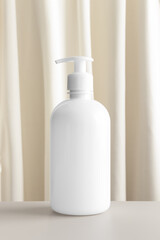 Obraz na płótnie Canvas White cosmetic liquid soap dispenser bottle mockup with a yellow textile.