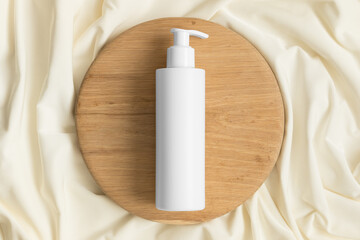 White cosmetic shampoo dispenser bottle mockup on the yellow textile.