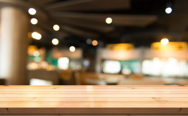 Empty wooden table top with lights bokeh on blur restaurant background.