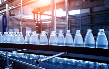 Conveyor belt with bottles of drinking water at a modern beverage plant.