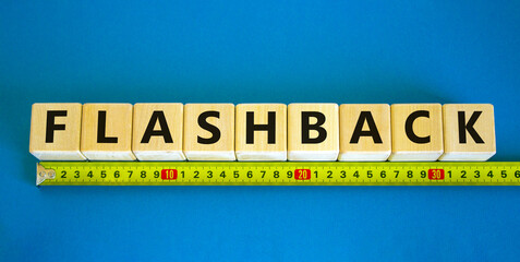 Flashback symbol. The concept word Flashback on wooden cubes. Yellow ruler. Beautiful blue table, blue background. Business and flashback concept. Copy space.