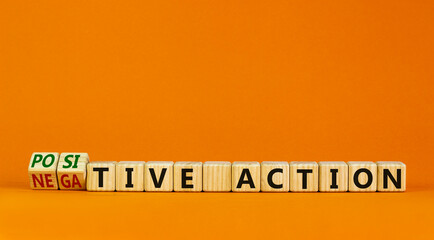 Positive or negative action symbol. Turned cubes and changed words negative action to positive action. Beautiful orange background, copy space. Business positive or negative action concept.