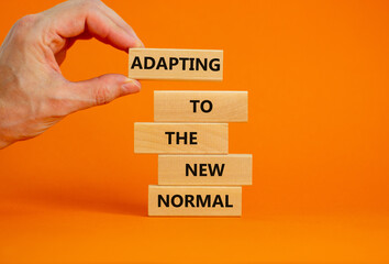 Adapting to the new normal symbol. Wooden blocks with words Adapting to the new normal on beautiful...