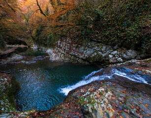Olginsky waterfall, and cascades in the Tsebeldinsky gorge, A narrow canyon with white rocks and a turquoise river, Abkhazia in  golden autumn time