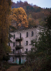 Obraz premium Ruined and abandoned hous with beautiful architecture in the Akarmara mining village in Abkhazia. Ghost city in the evening autumn.