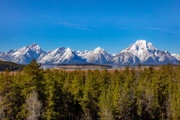 Beautiful snow-capped mountains. Golden autumn forest.  Grand Teton National Park, Wyoming, USA