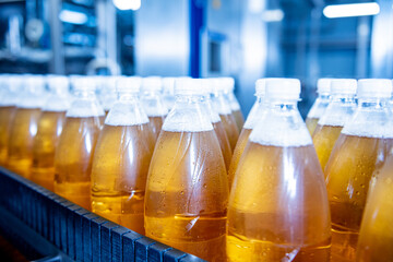 Conveyor belt with bottles for juice or water at a modern beverage plant
