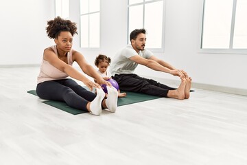Fototapeta na wymiar Couple and daughter stretching at sport center