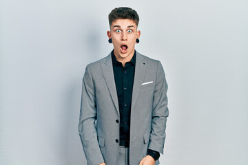 Young caucasian boy with ears dilation wearing business jacket afraid and shocked with surprise and amazed expression, fear and excited face.