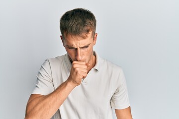 Young caucasian man wearing casual white polo feeling unwell and coughing as symptom for cold or bronchitis. health care concept.