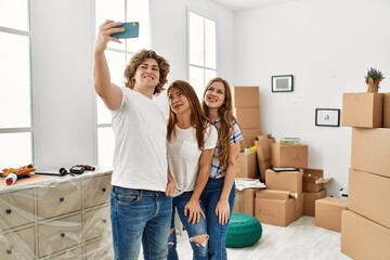 Mother and couple smiling confident make selfie by the smartphone standing at home