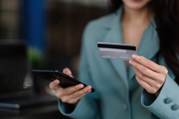 Close up woman in a cafe shopping online with credit card and mobile phone